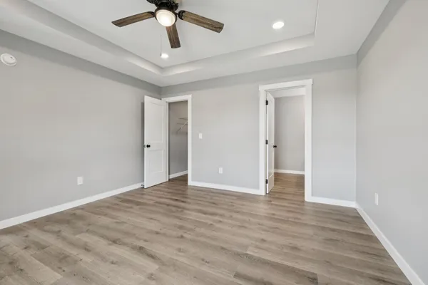 wooden floor in an empty room with a ceiling fan