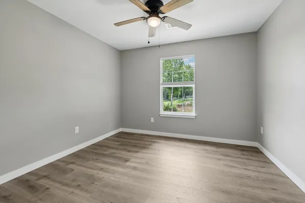wooden floor in an empty room with a window