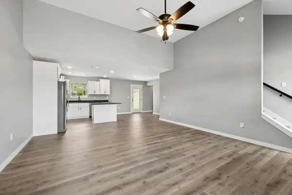 a view of an empty room with a window and wooden floor