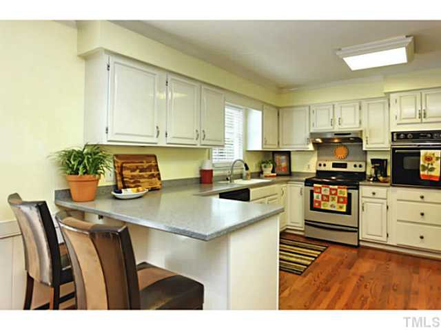 5504 Shimer Farm Lane Raleigh, NC 27614 - Photo 10 of 25 a kitchen with stainless steel appliances kitchen island granite countertop a refrigerator a stove top oven and white cabinets