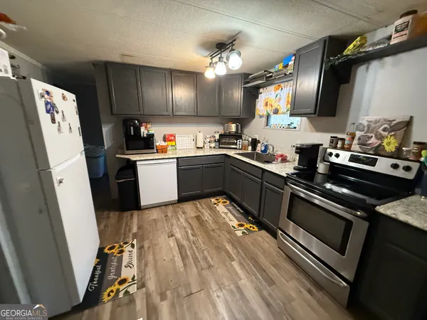 a kitchen with granite countertop a sink stove and refrigerator