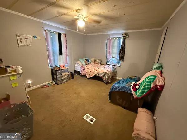 a bed sitting in a bedroom next to a window