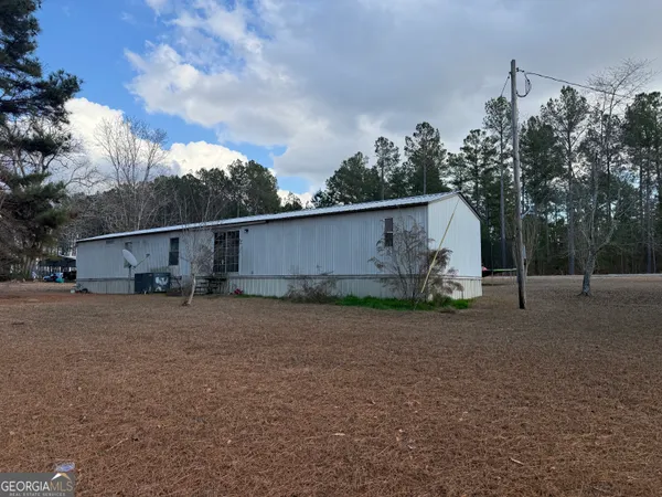 a view of a house with backyard and trees