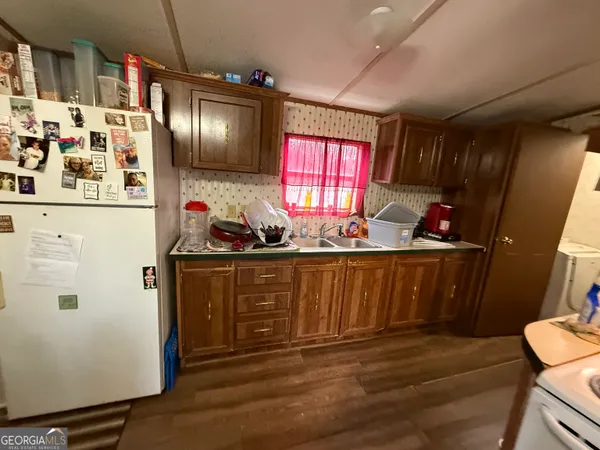 a room with stainless steel appliances granite countertop a stove a chimney a refrigerator and furniture