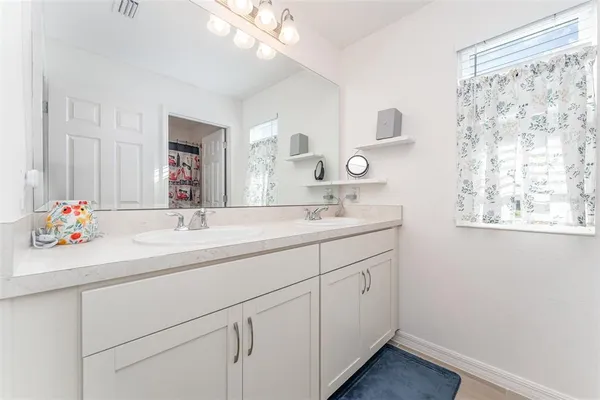 a bathroom with a double vanity sink and a mirror