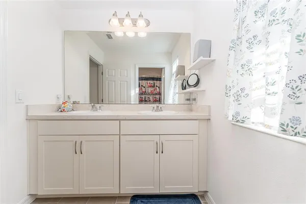 a bathroom with a sink vanity and a mirror