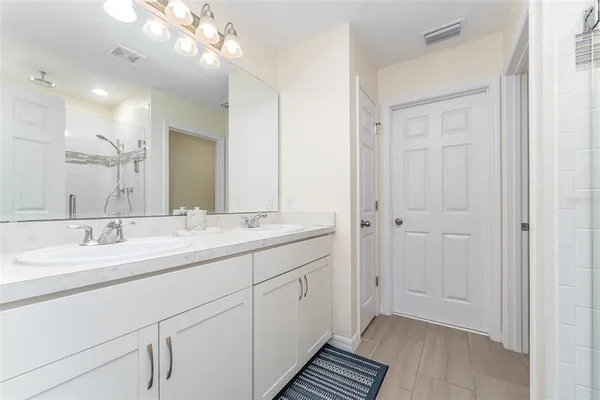 a bathroom with a double vanity sink and a mirror