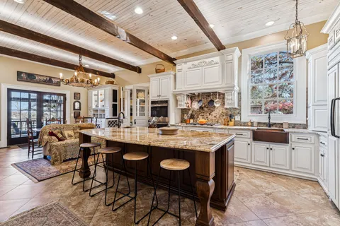 a dining room with furniture a chandelier and wooden floor