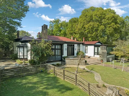 a front view of a house with a yard and trees