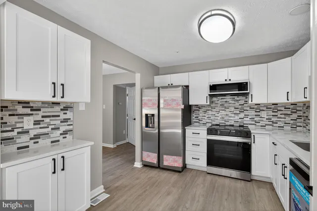 a kitchen with stainless steel appliances a stove refrigerator sink and microwave