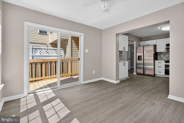 an empty room with wooden floor and a rug