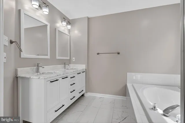 a bathroom with a tub sink and mirror