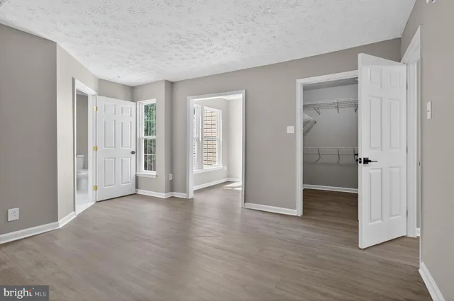 an empty room with wooden floor and closet