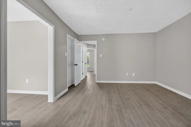 a view of an empty room with wooden floor
