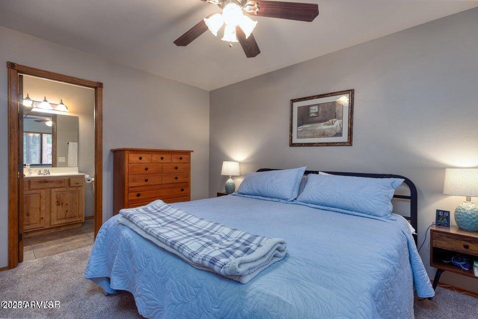 4800 West Tatanka Loop Show Low, AZ 85901 - Photo 16 of 36 a bedroom with a large bed and a chandelier