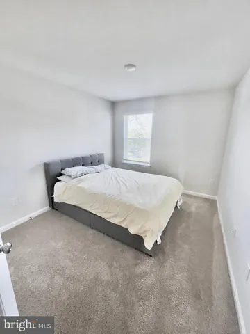 a large bed sitting in a room next to a window