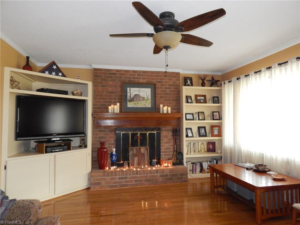 2103 Collinstown Road Westfield, NC 27053 - Photo 3 of 30 Cozy living room with large picture window, brick fireplace and shelving!