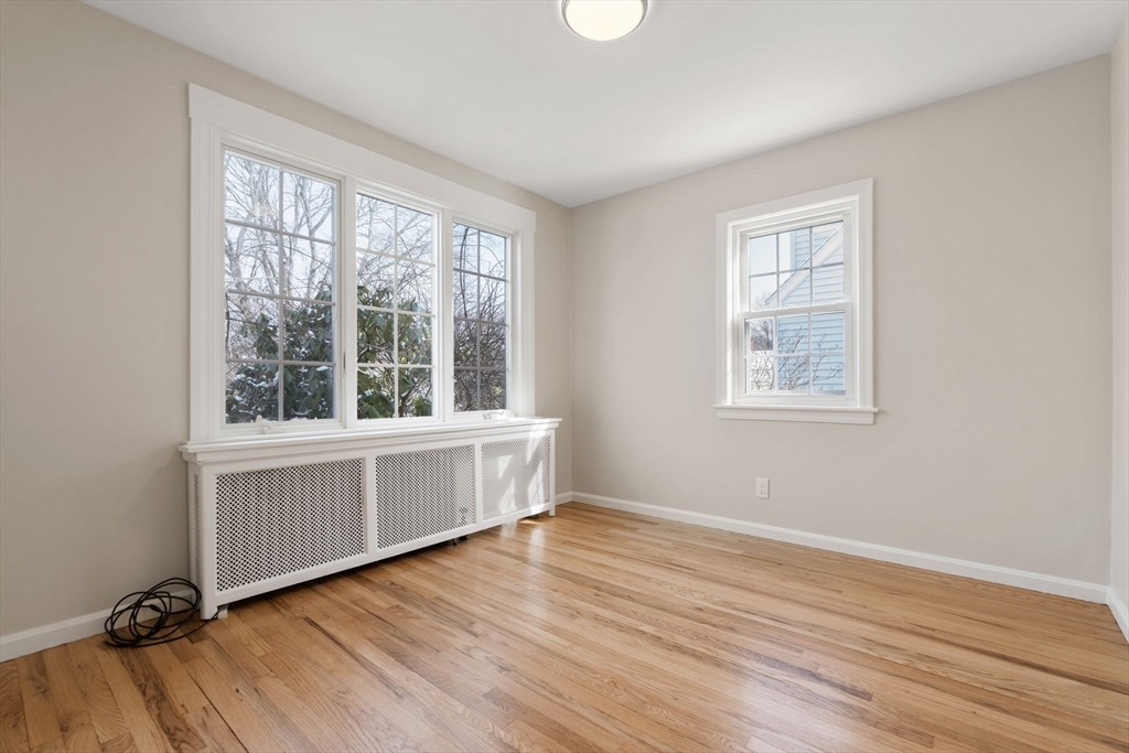10 MacArthur Circle Peabody, MA 01960 - Photo 9 of 17 a view of an empty room with a window and wooden floor