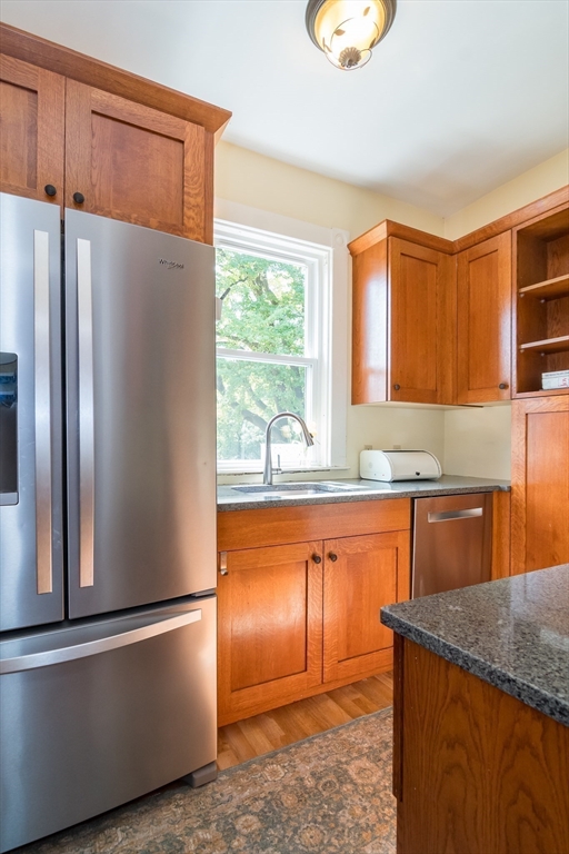 224 Bacon Street Natick, MA 01760 - Photo 12 of 28 a kitchen with stainless steel appliances granite countertop a refrigerator a stove and a sink with large window