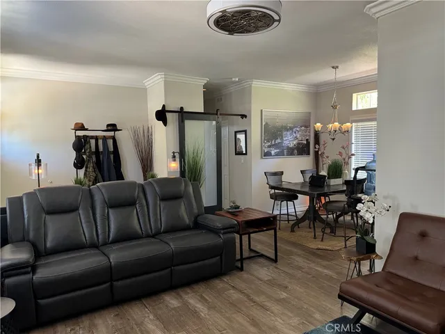 a living room with furniture and a dining table with wooden floor