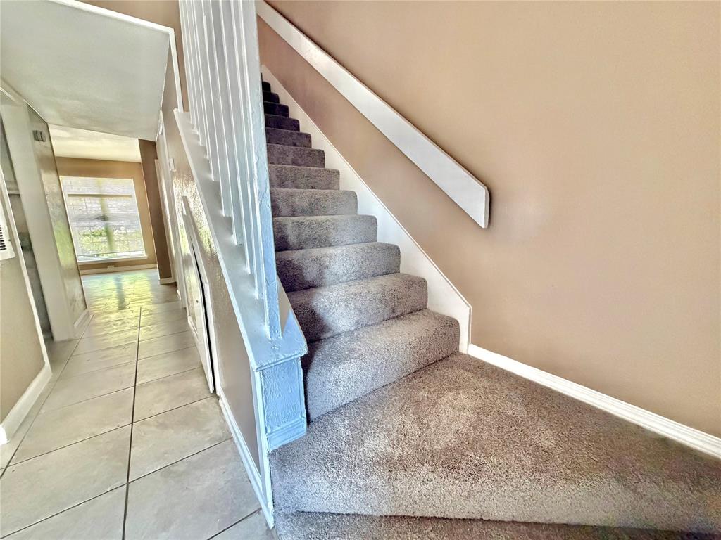 8001 Rothington Road, Unit 3137 Dallas, TX 75227 - Photo 16 of 21 Carpeted staircase with white balustrade and handrail