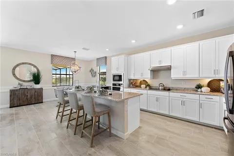 a kitchen with cabinets a sink and chairs