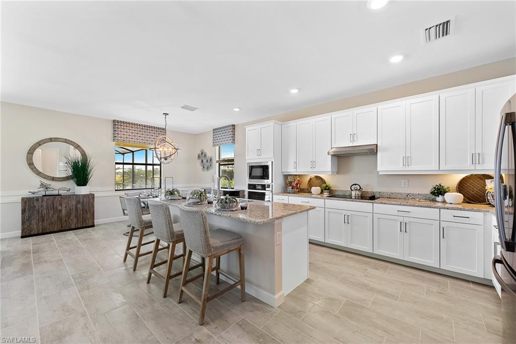 11581 Timber Creek Drive Fort Myers, FL 33913 - Photo 13 of 50 a kitchen with cabinets a sink and chairs
