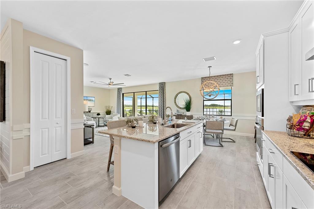 11581 Timber Creek Drive Fort Myers, FL 33913 - Photo 50 of 50 a open kitchen with a stove top oven a sink a dining table and chairs