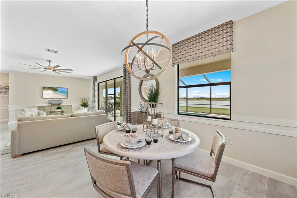 11581 Timber Creek Drive Fort Myers, FL 33913 - Photo 16 of 50 a dining room with wooden floor a chandelier a wooden table and chairs