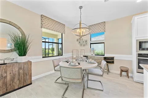 a dining room with wooden floor a chandelier a wooden table and chairs