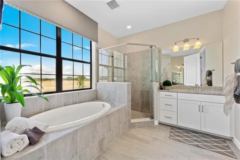 a spacious bathroom with a granite countertop tub shower and mirror