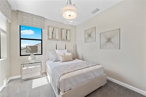 a bedroom with a white bed and a chandelier