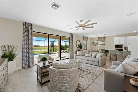a living room with furniture floor to ceiling window and a potted plant