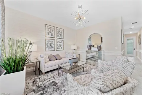 a living room with furniture and a chandelier