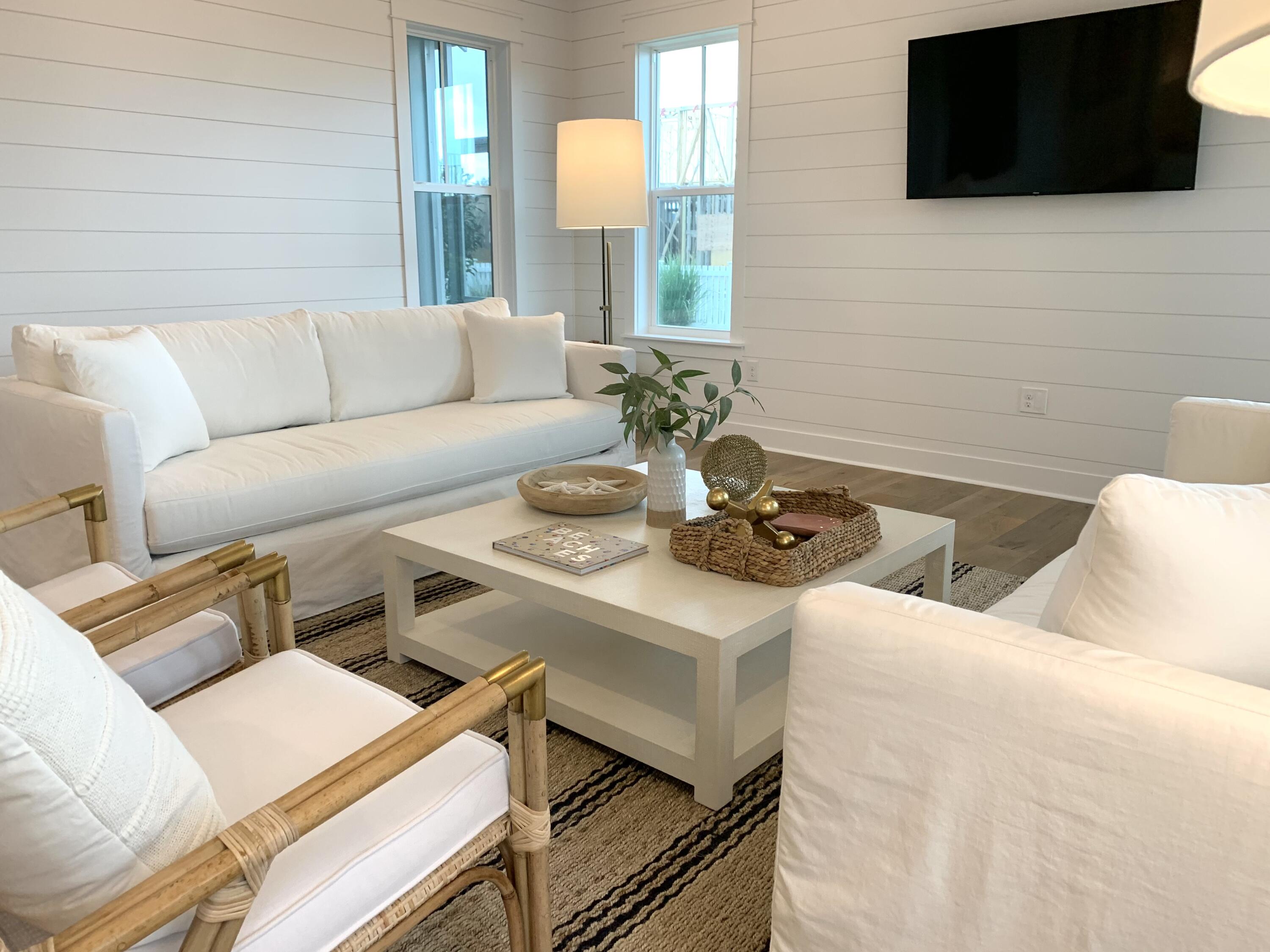 82 Sidecamp Road Watersound, FL 32461 - Photo 28 of 32 a living room with couches a flat screen tv and a fireplace