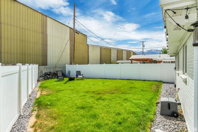 48 Moon Ridge Drive Murray, UT 84107 - Photo 25 of 30 Expansive grassy yard with white vinyl fencing and a gravel perimeter