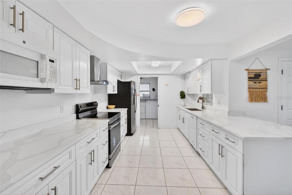 11225 59th Avenue Seminole, FL 33772 - Photo 4 of 15 a large kitchen with cabinets and stainless steel appliances