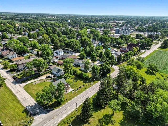 an aerial view of residential houses with outdoor space and trees