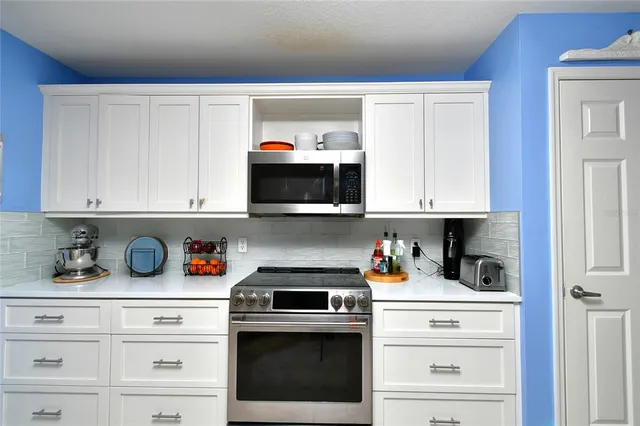 a kitchen with white cabinets and white appliances