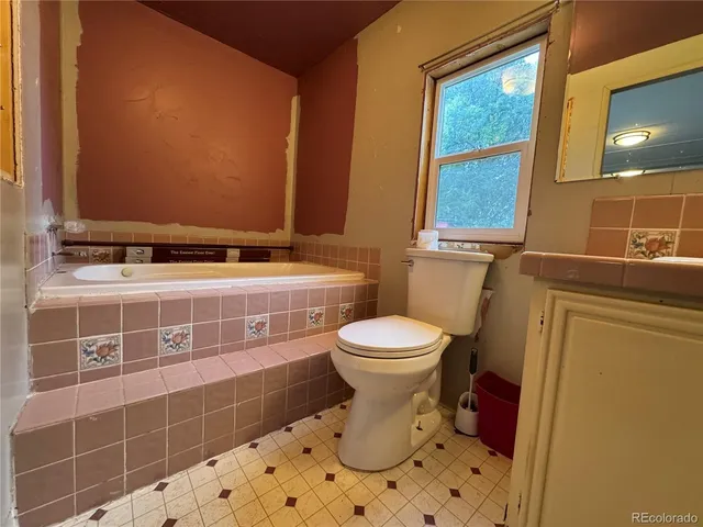 a bathroom with a toilet sink and mirror
