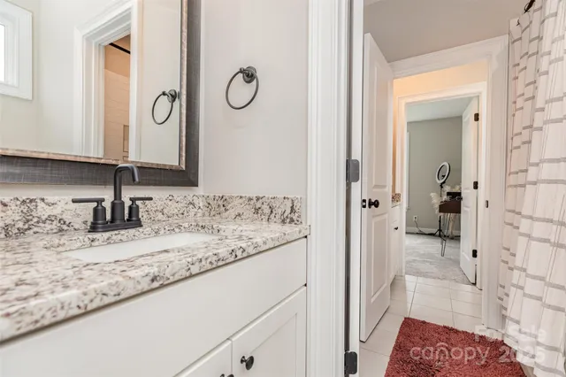 a bathroom with a granite countertop sink and a mirror