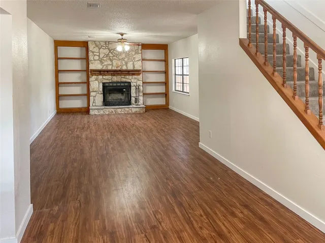 wooden floor fireplace and windows in an empty room