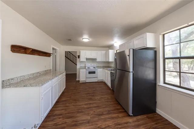 a kitchen with stainless steel appliances granite countertop a refrigerator and a stove