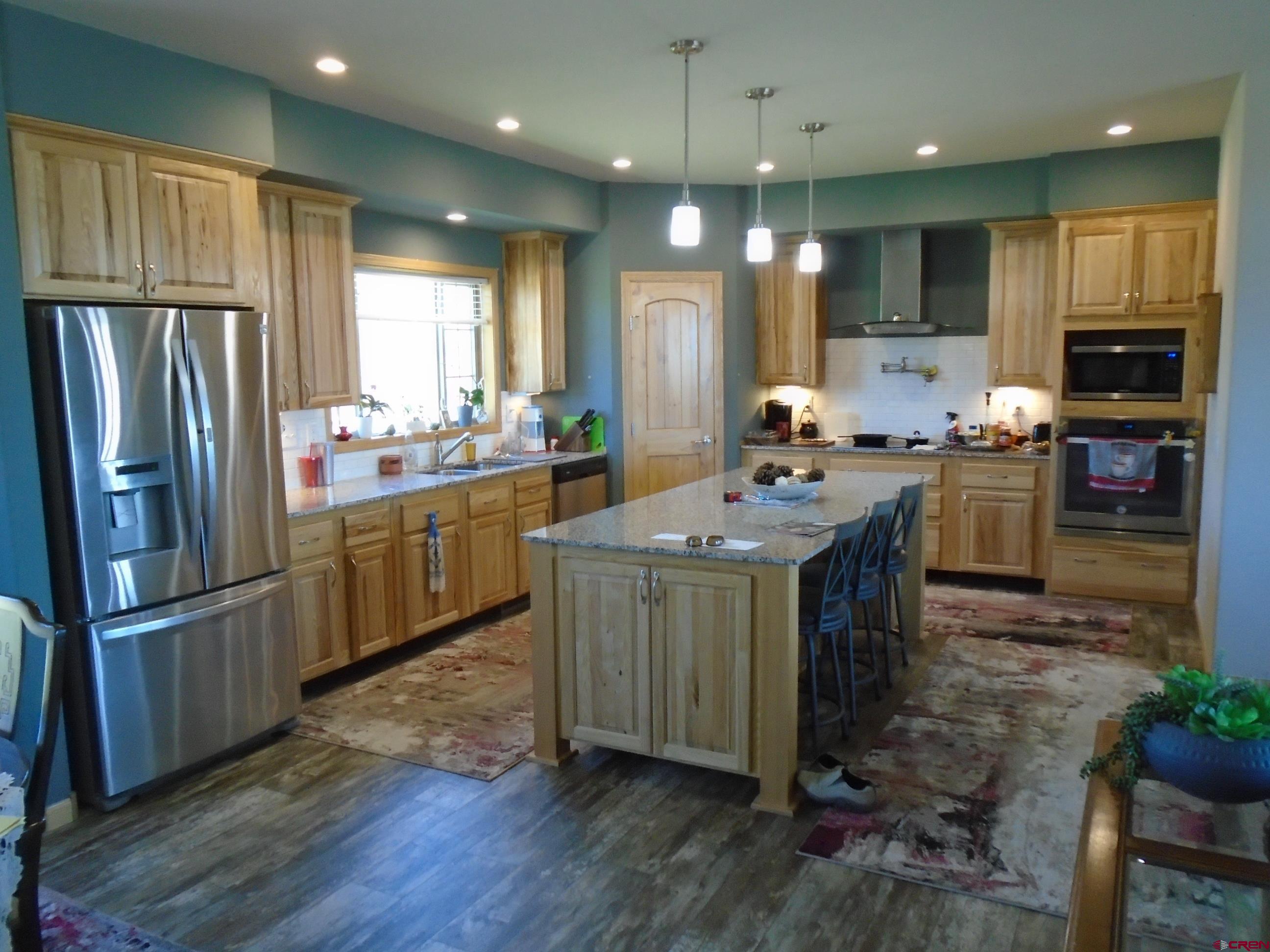 23041 T Road Cedaredge, CO 81413 - Photo 11 of 28 a kitchen with kitchen island granite countertop a sink cabinets and stainless steel appliances
