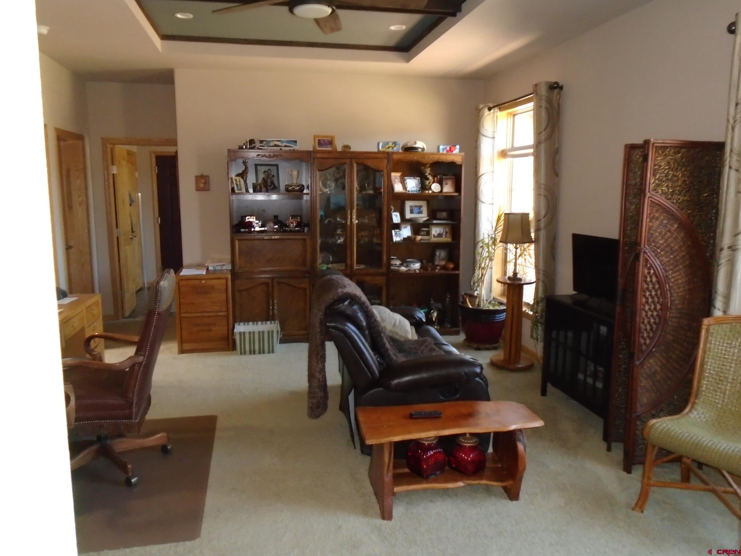 23041 T Road Cedaredge, CO 81413 - Photo 15 of 28 a living room with furniture a flat screen tv and a window