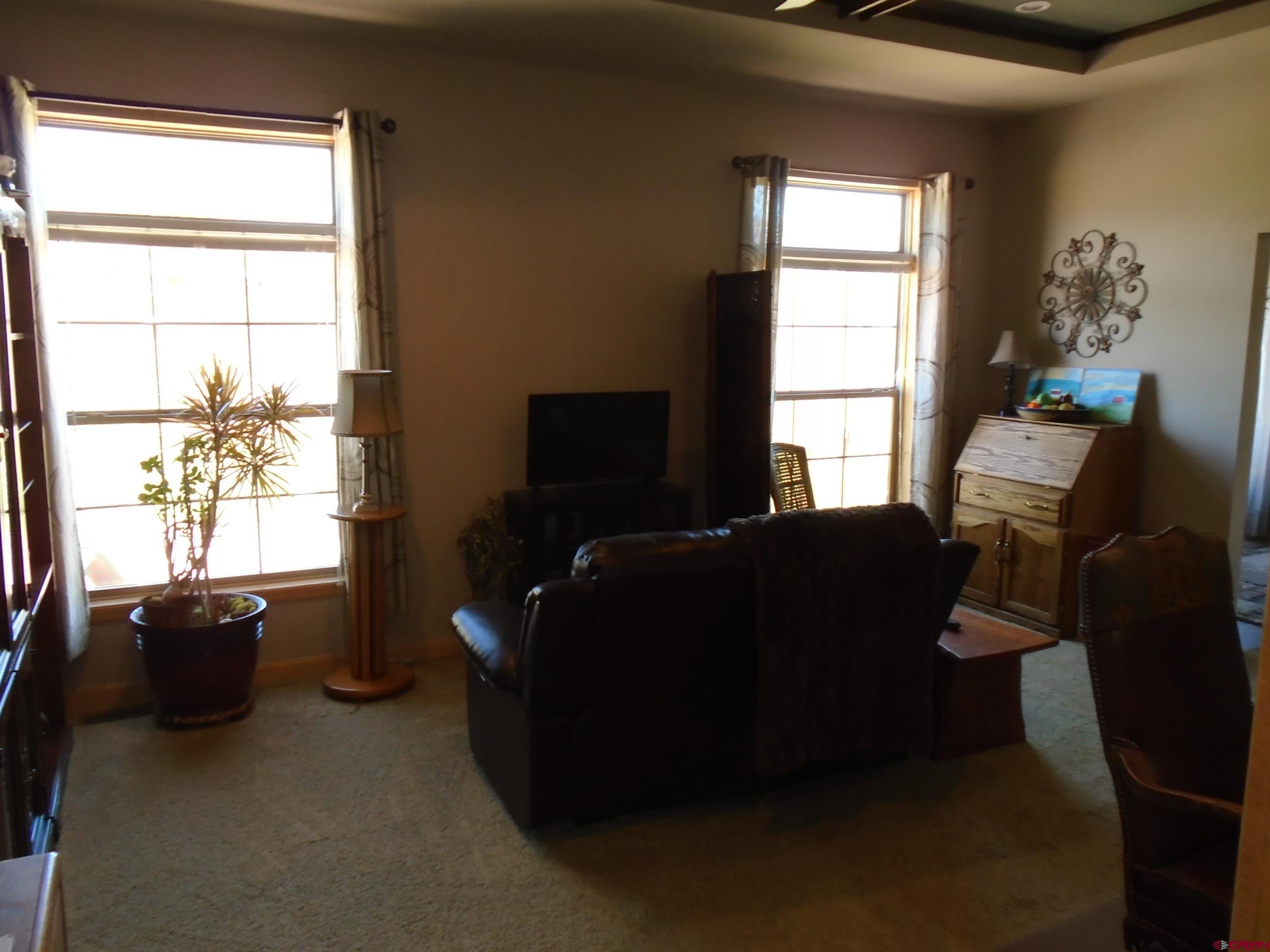 23041 T Road Cedaredge, CO 81413 - Photo 16 of 28 a living room with furniture windows and a flat screen tv