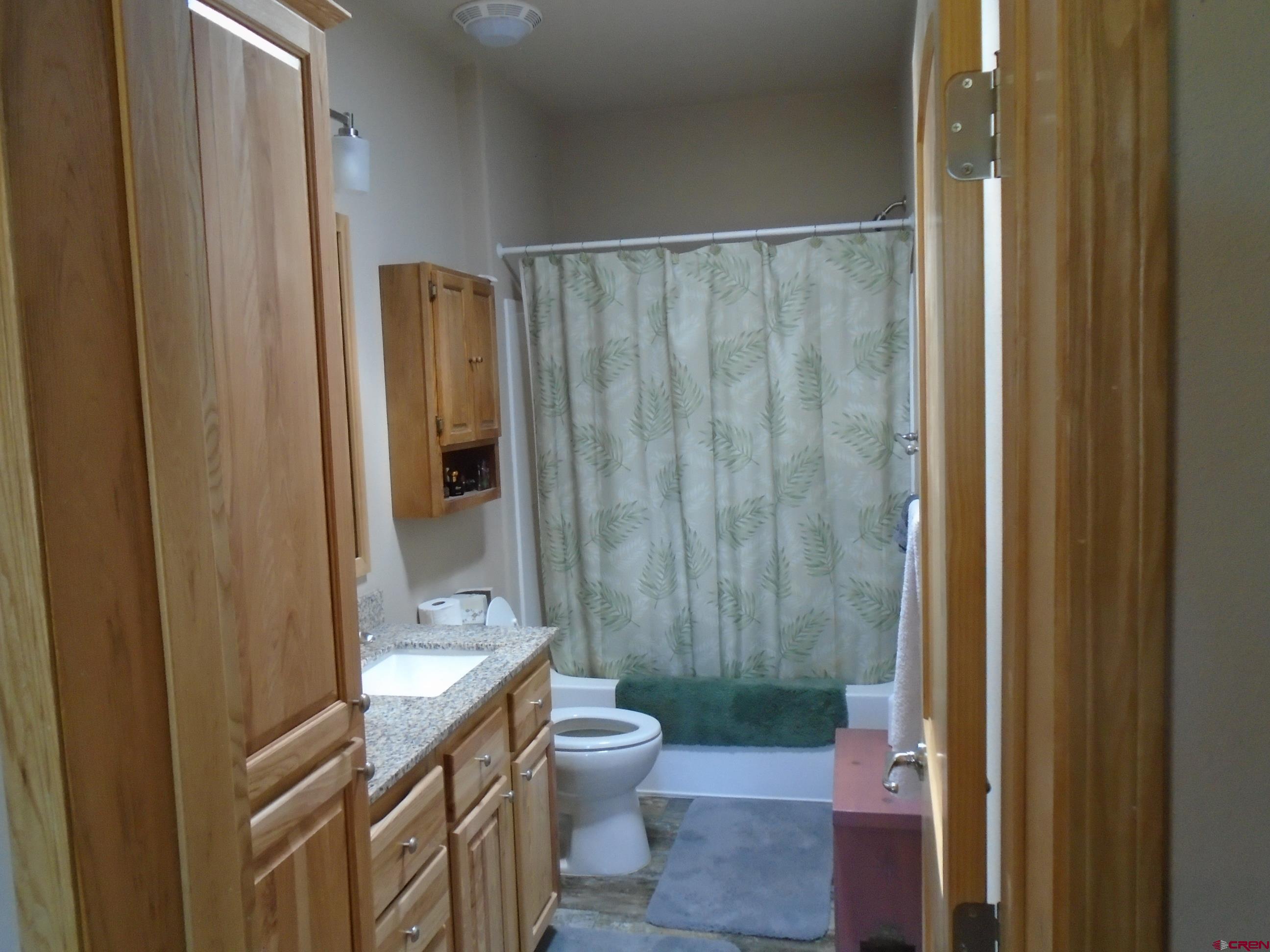 23041 T Road Cedaredge, CO 81413 - Photo 17 of 28 a bathroom with a granite countertop sink toilet and shower