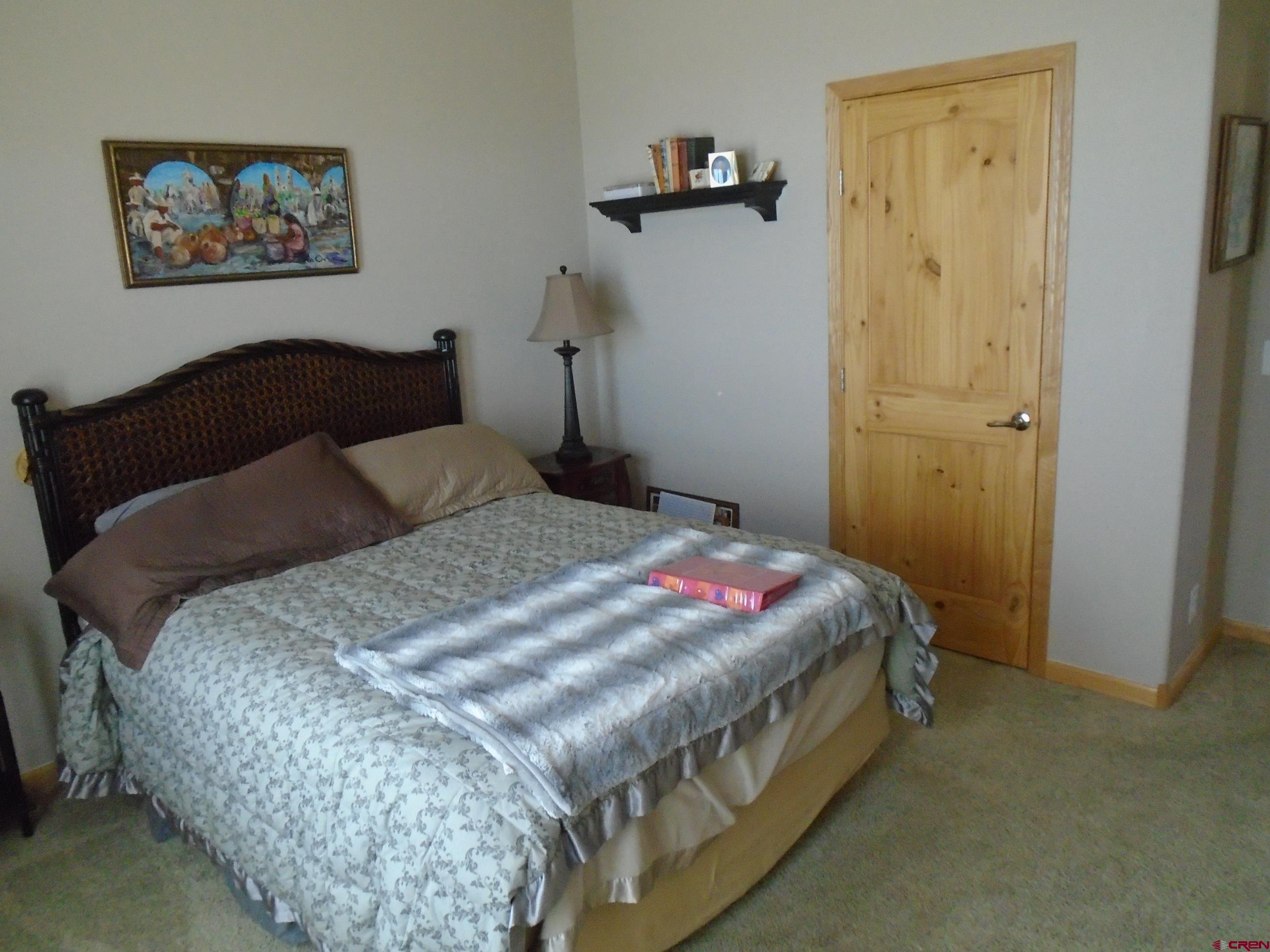 23041 T Road Cedaredge, CO 81413 - Photo 18 of 28 a bedroom with a bed and wall painting