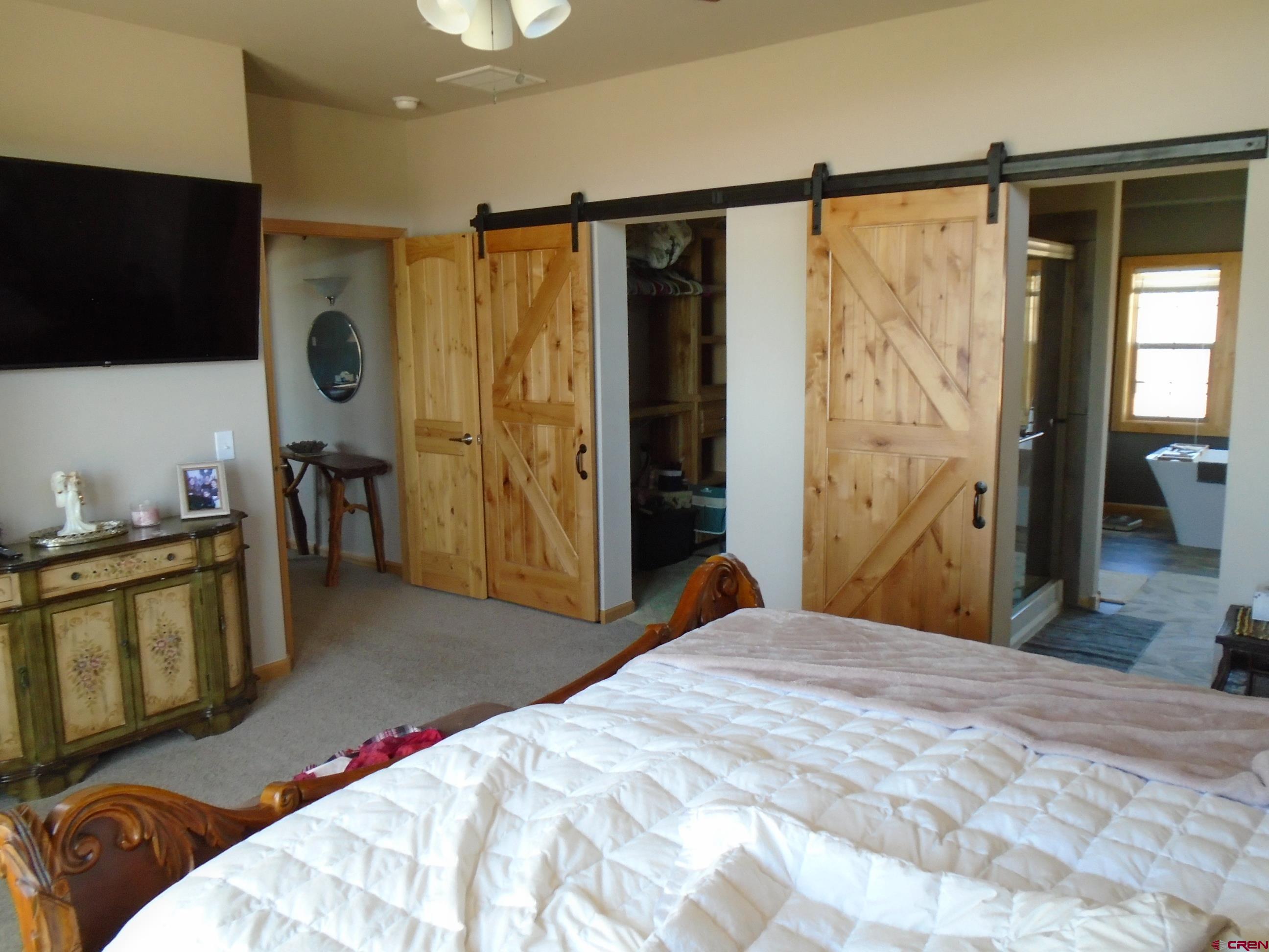 23041 T Road Cedaredge, CO 81413 - Photo 26 of 28 a bedroom with a bed and a flat tv screen