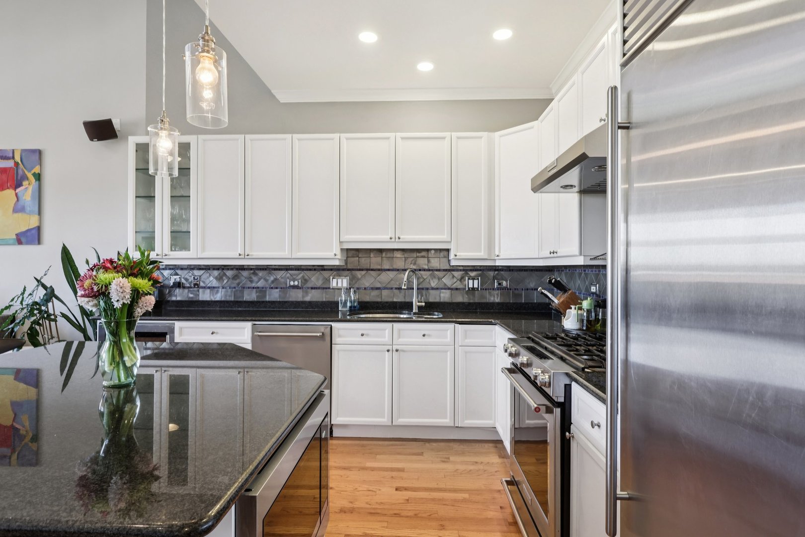 1473 West Irving Park Road, Unit 4E Chicago, IL 60613 - Photo 11 of 44 a kitchen with stainless steel appliances granite countertop a sink a stove and a refrigerator